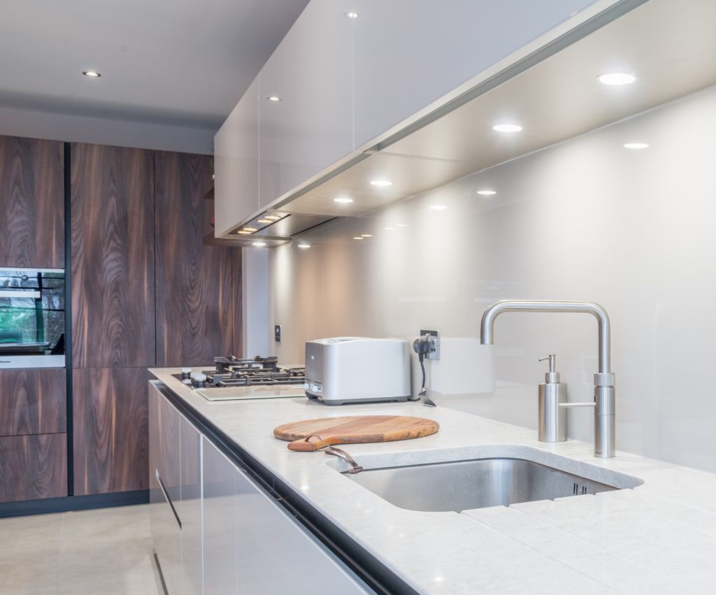 Image of a minimalistic kitchen featuring overhead spotlights that brighten the whole kitchen.