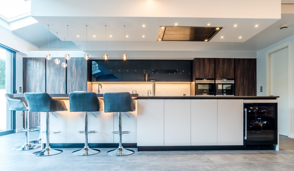 Image of a white open-plan kitchen design with a wine fridge.