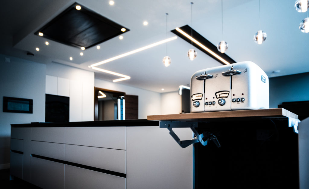A dramatic image of the modern Doimo Aspen kitchen range showcasing modern LED kitchen lighting and appliances.
