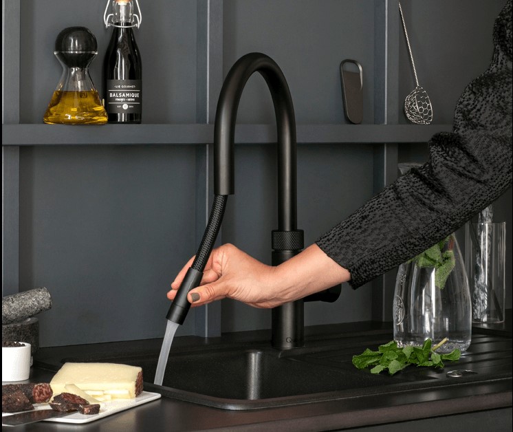 A grey kitchen countertop and sink with a black Quooker Flex tap