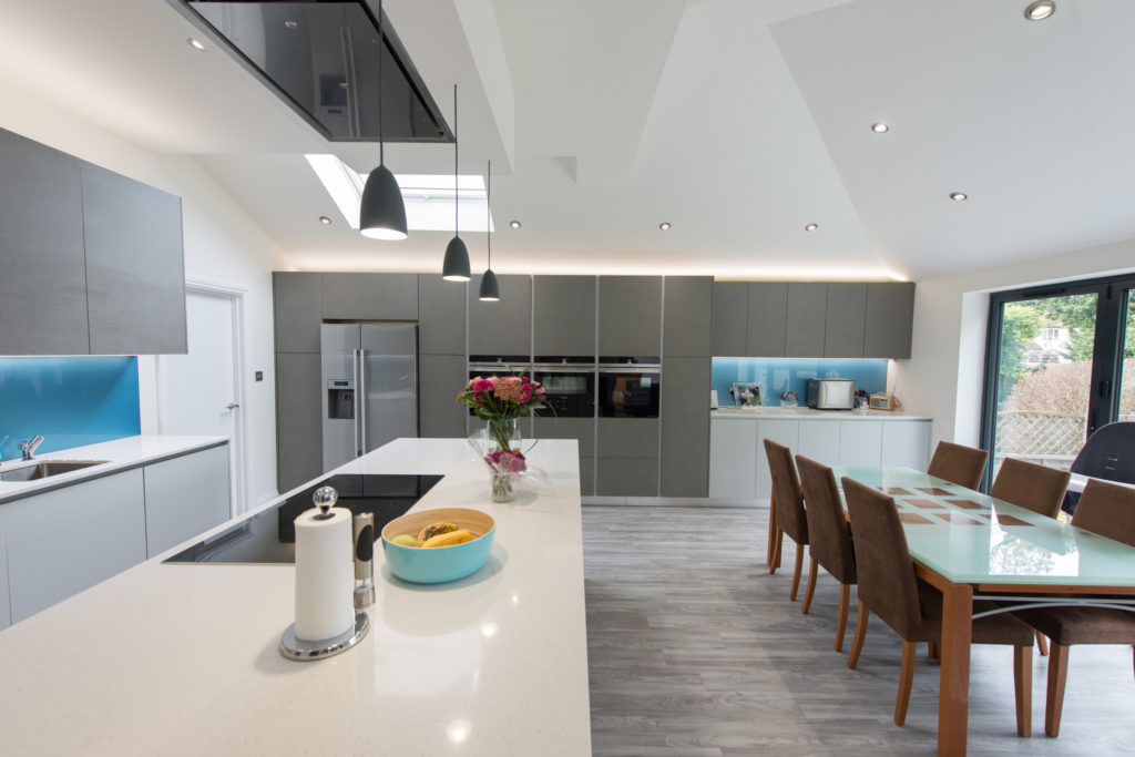 A light grey kitchen with pale blue splashbacks