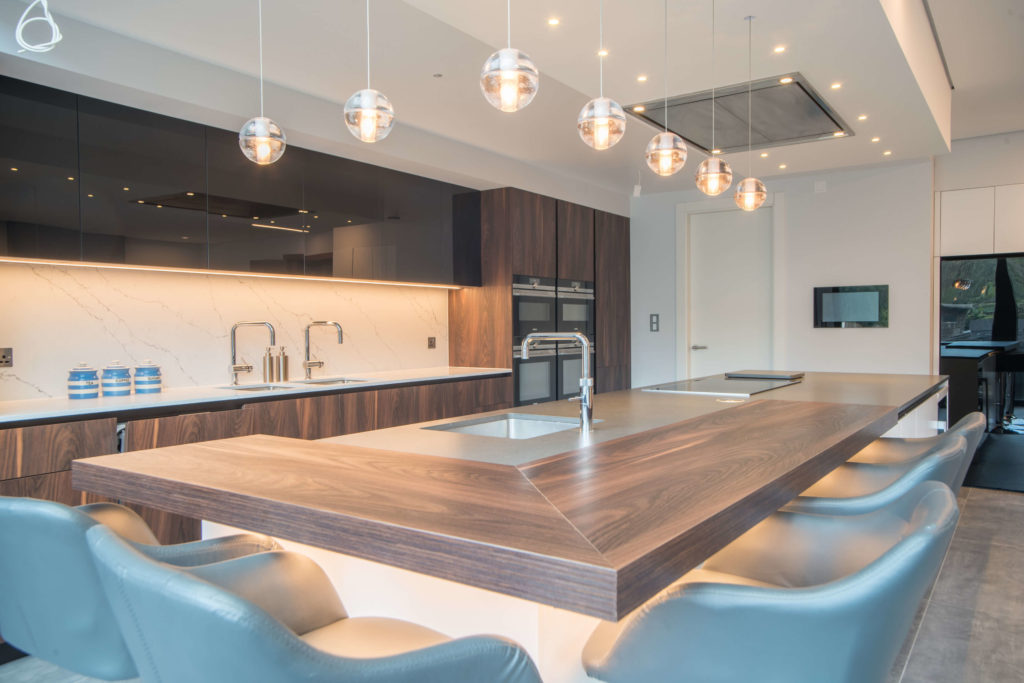 wooden kitchen with large island and breakfast bar with stools, black glass cabinets